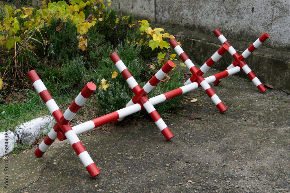 Mlitary fence with barbed wire blocks the road in the forest. Road