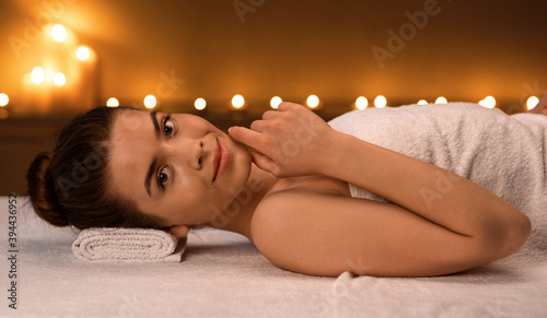 Smiling lady laying on massage table, enjoying aromatherapy session