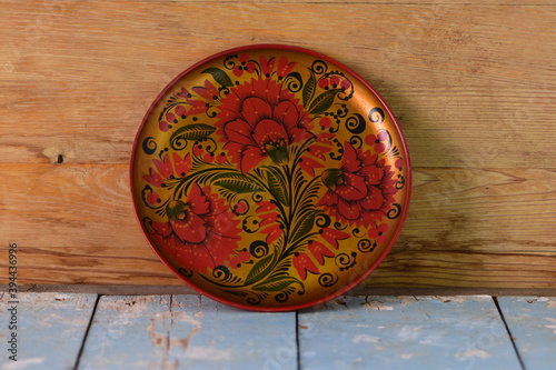 round painted dish on old wooden background