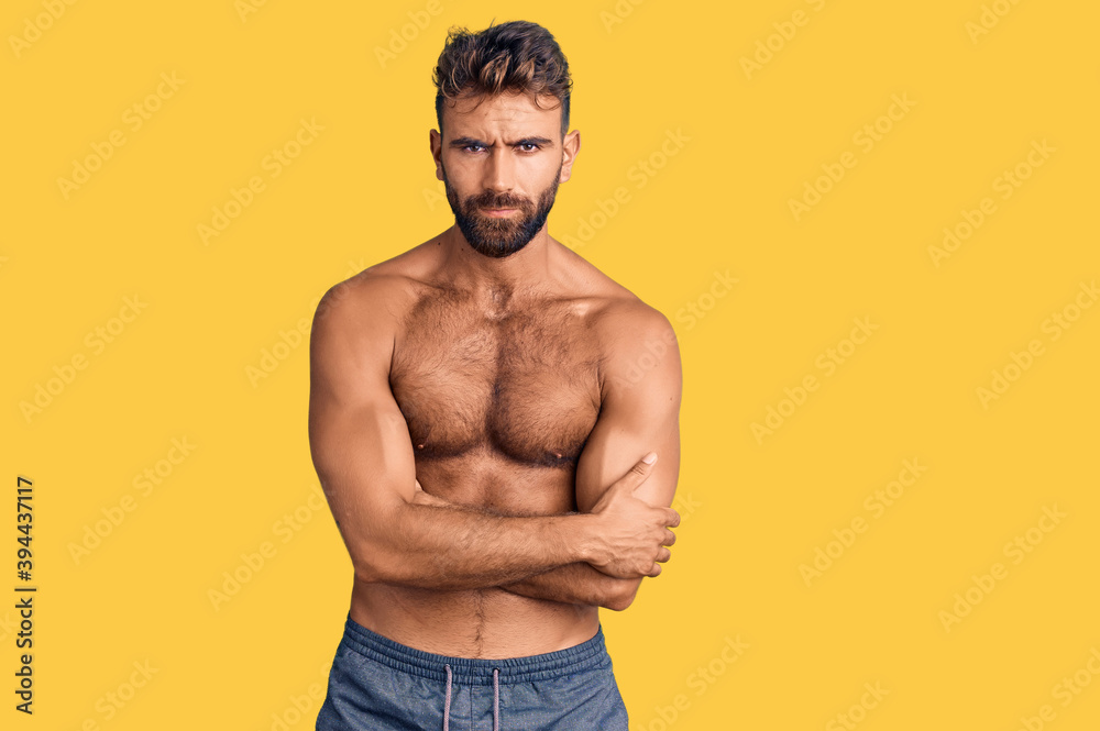 Fototapeta premium Young hispanic man wearing swimwear shirtless skeptic and nervous, disapproving expression on face with crossed arms. negative person.