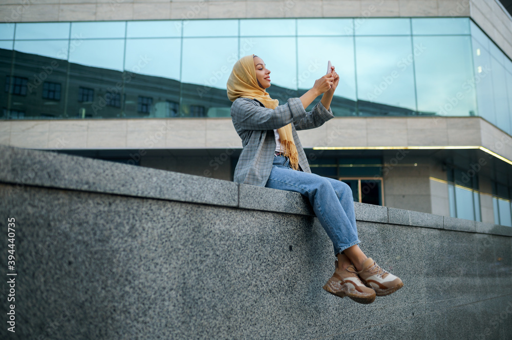 Arab girl makes selfie at the building in downtown