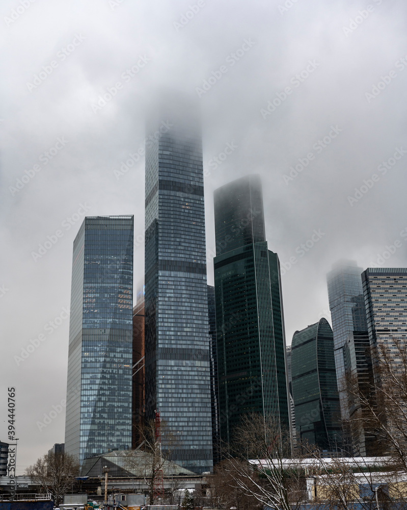 cityscape with high-rise buildings whose upper floors have melted into fog