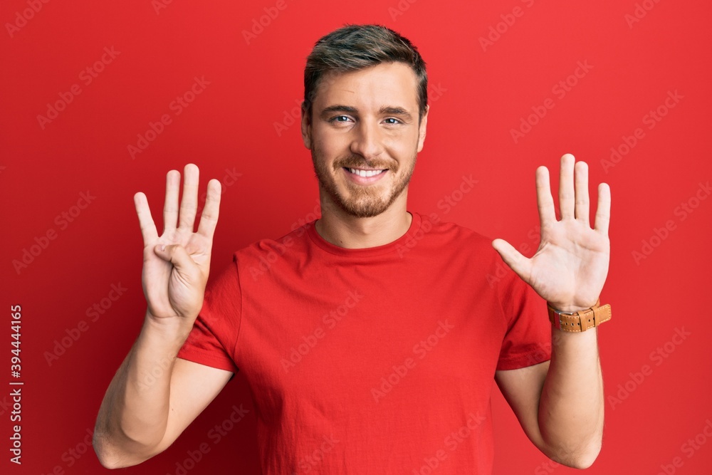 Handsome caucasian man wearing casual red tshirt showing and pointing up with fingers number nine while smiling confident and happy. Handsome caucasian man wearing casual red tshirt showing and pointing up with fingers number nine while smiling confident and happy.