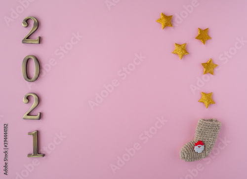 Christmas 2021. Coronavirus new year minimal concept. Flat lay with metal numbers and decorative stars on pink background. top view, copy space