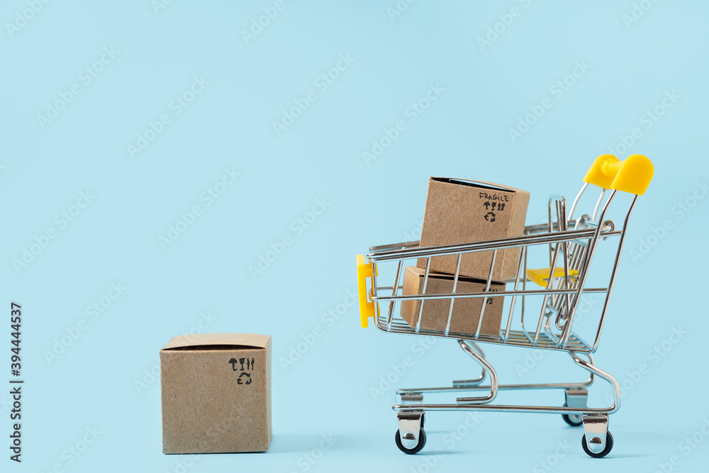 Toy shopping cart with boxes on blue background