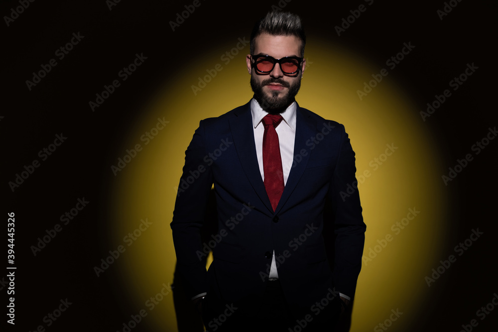 Fototapeta premium smiling businessman in navy blue suit holding hand in pockets
