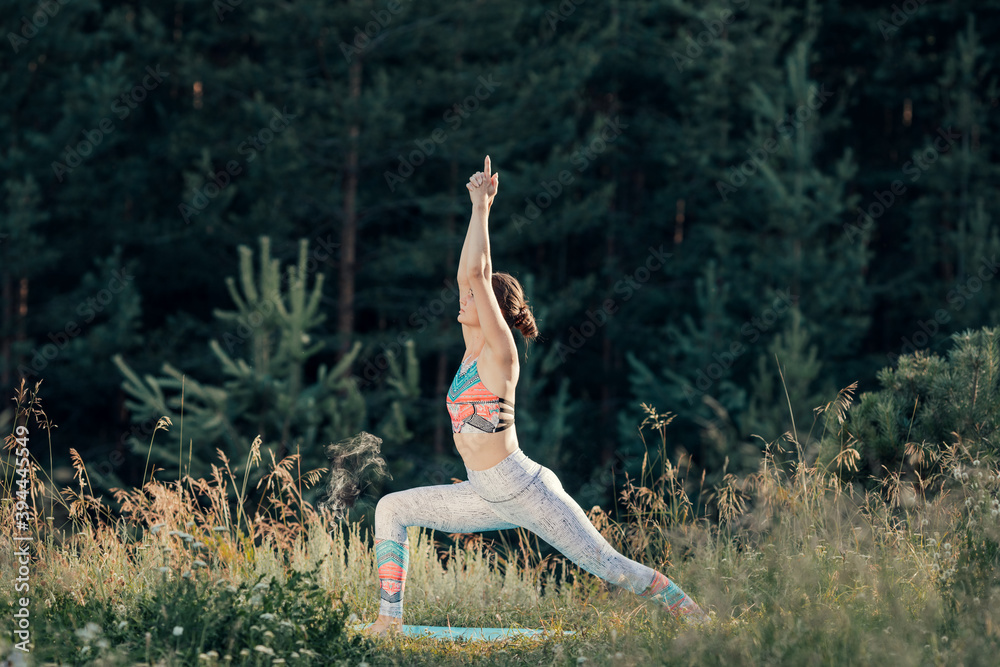 A woman does yoga in the open air. The concept of sport.