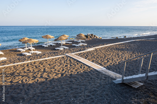 Black Beach with volcanic sand in Perissa, a tourist resort in Santorini. Cyclades Islands, Greece © vivoo