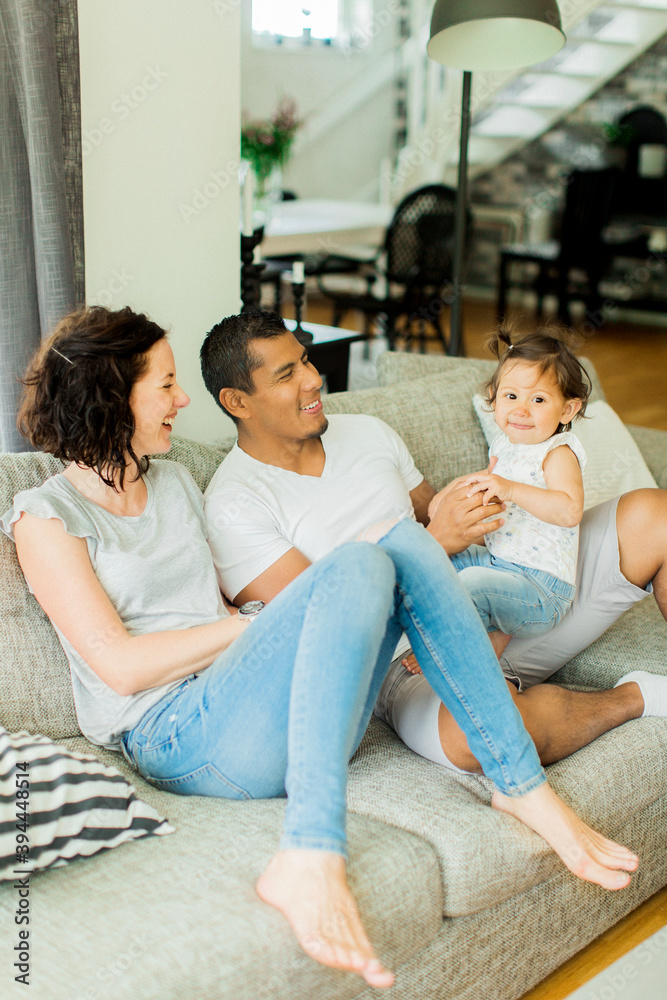 Parents with daughter sitting on sofa, Sweden Parents with daughter sitting on sofa, Sweden