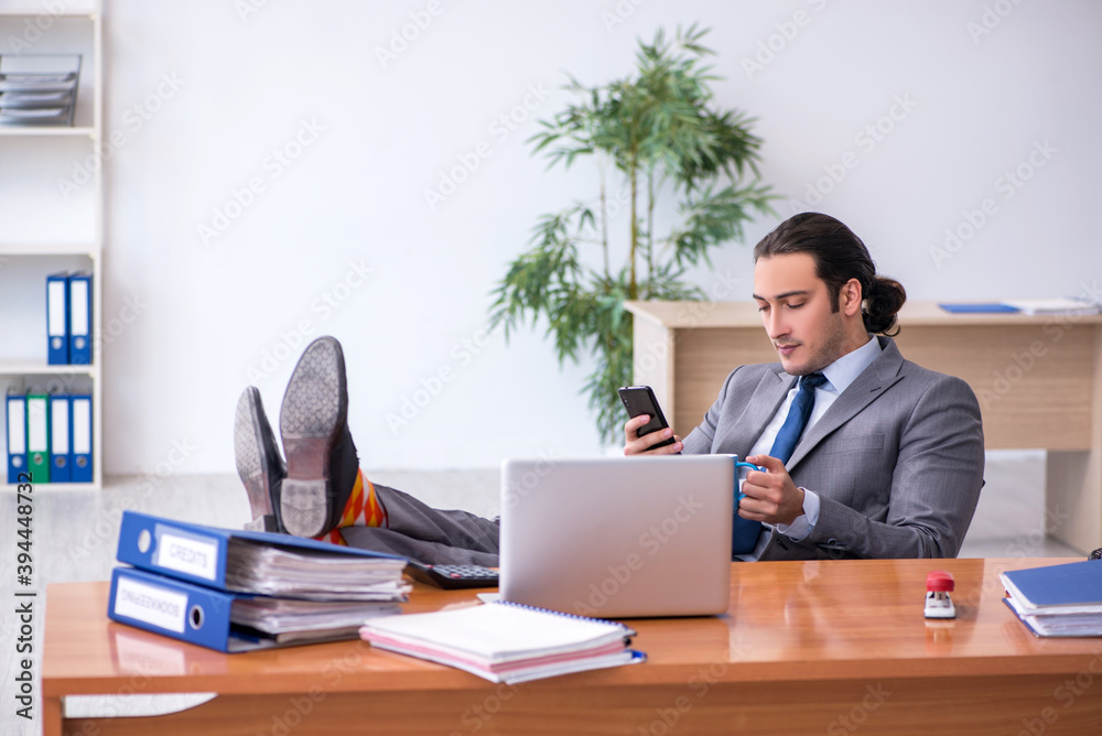 Young male employee drinking coffee in the office Young male employee drinking coffee in the office