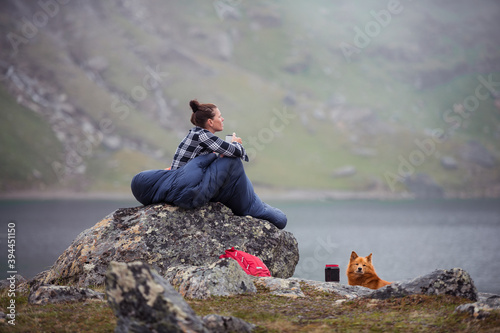 Woman in sleeping bag at lake, Sweden