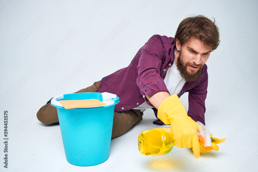 cleaner in rubber gloves washing floors housework light background