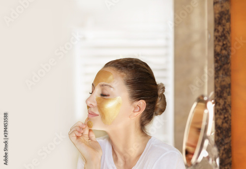 Anti-aging therapy. young woman applying facial mask. woman moisturizing face mask. Cosmetology and skin care concept..