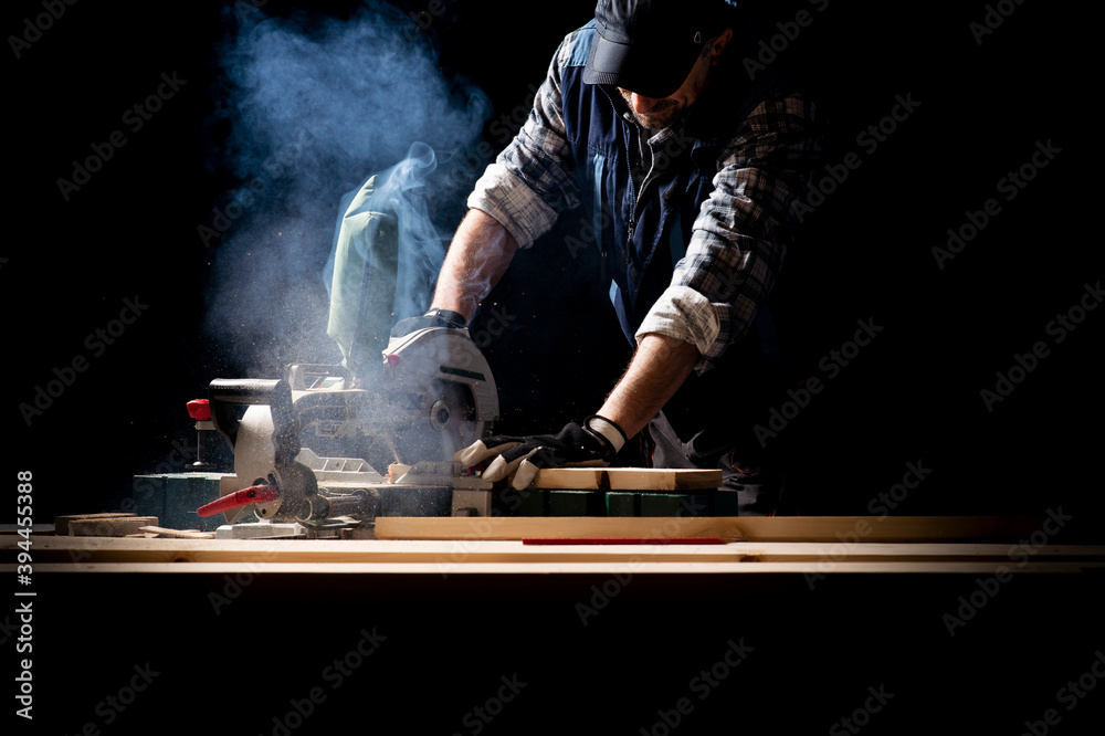 Carpenter working on woodworking machines in carpentry shop - obrazy, fototapety, plakaty 