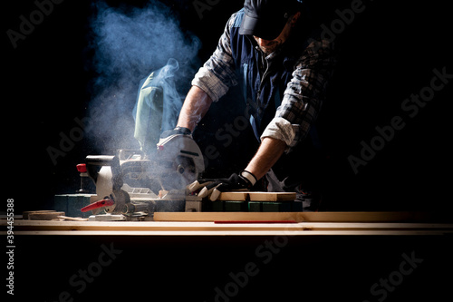 Carpenter working on woodworking machines in carpentry shop