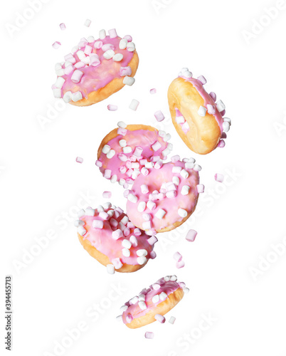 Pink donuts with marshmallows are falling down on a white background