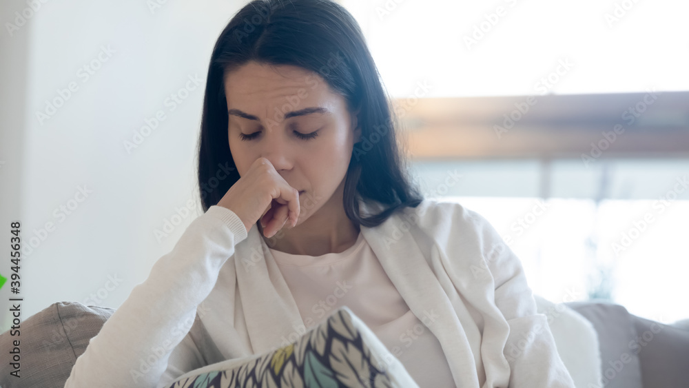 Swallowing tears. Crying upset depressed teenage or millennial female abuse violence victim sitting in corner of couch suffering of grief heartbreak loneliness cheating divorce drug alcohol addiction Swallowing tears. Crying upset depressed teenage or millennial female abuse violence victim sitting in corner of couch suffering of grief heartbreak loneliness cheating divorce drug alcohol addiction