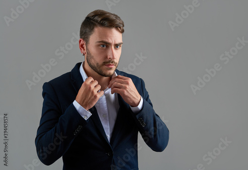 Close up portrait young man businessman. Caucasian guy business suit studio gray background. © Andrii