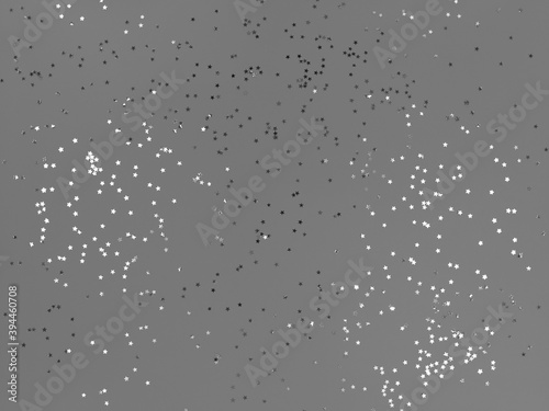 Confetti stars sparkling on a grey background.