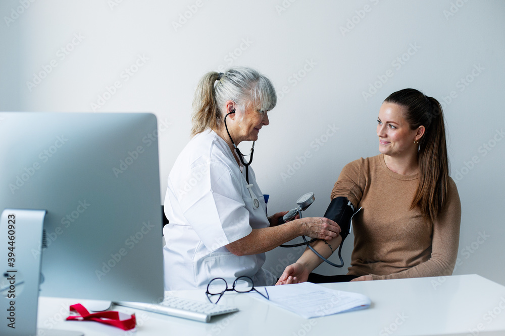 © Johnér - Doctor checking patients blood pressure, Sweden