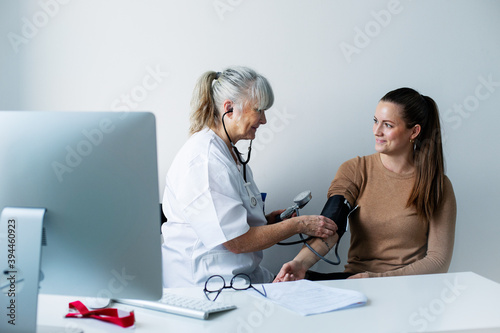 Doctor checking patients blood pressure, Sweden photo