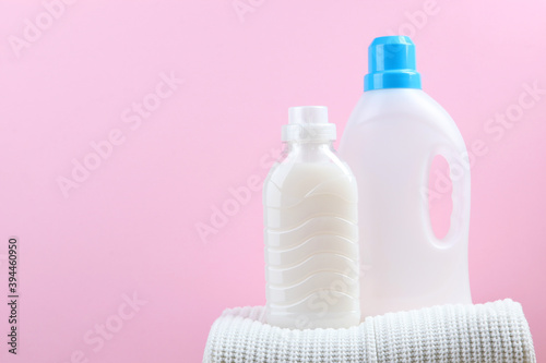 Laundry detergent bottles and woolen sweaters on the table. Household chemicals