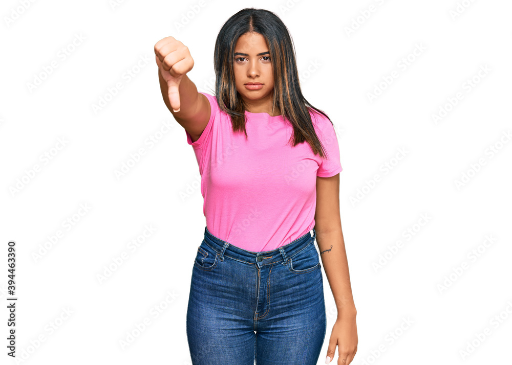 Young latin girl wearing casual clothes looking unhappy and angry showing rejection and negative with thumbs down gesture. bad expression. Young latin girl wearing casual clothes looking unhappy and angry showing rejection and negative with thumbs down gesture. bad expression.
