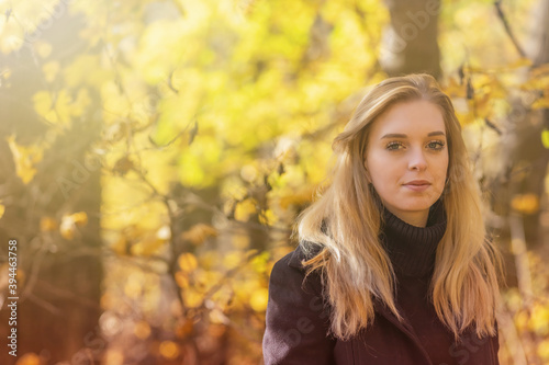 Attractive girl is posing in autumn park. Horizontally. 