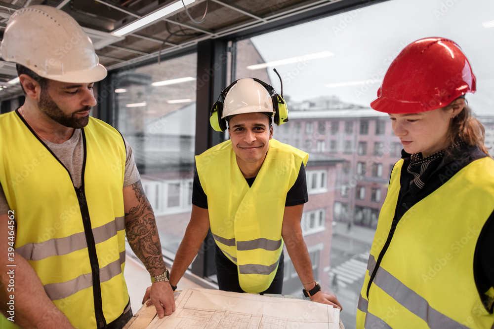 Workers reviewing blueprint at construction site, Sweden Workers reviewing blueprint at construction site, Sweden