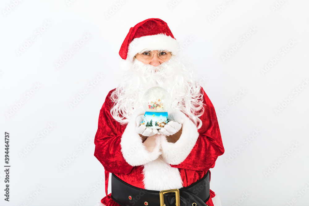 Santa Claus with a christmas snow globe in her hands, on white background. Christmas concept