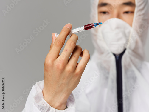 Fototapeta Naklejka Na Ścianę i Meble -  male laboratory assistant syringe in hands research treatment