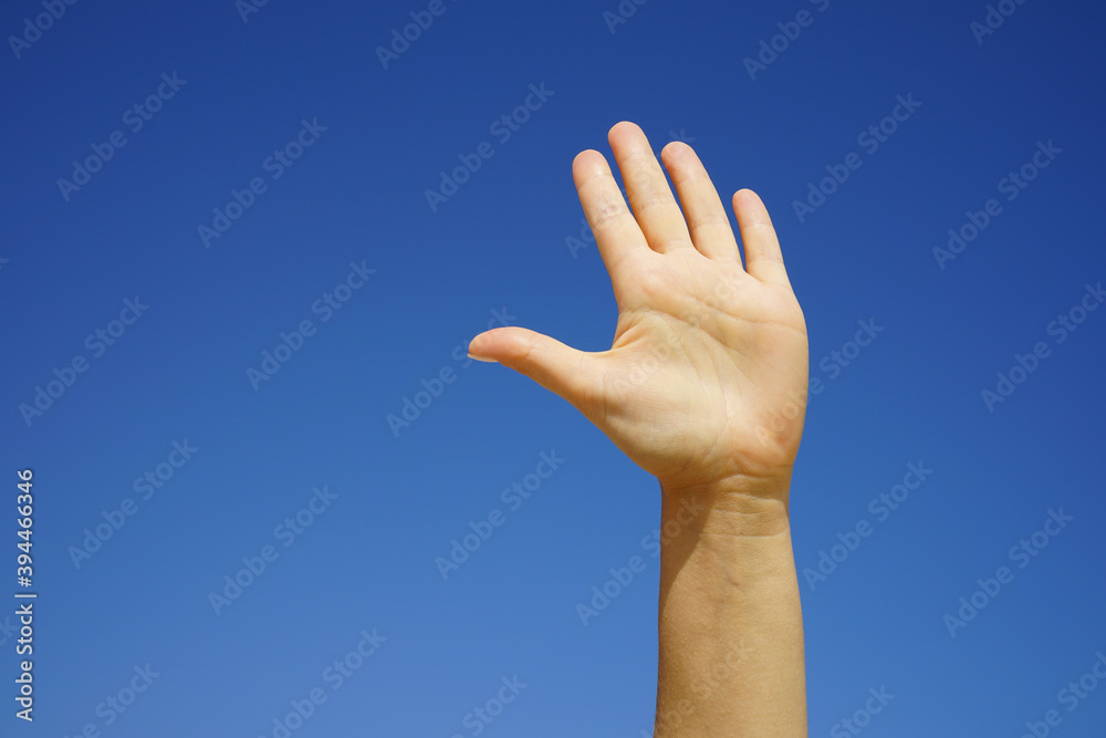 female hand close-up against a cloudless blue sky female hand close-up against a cloudless blue sky