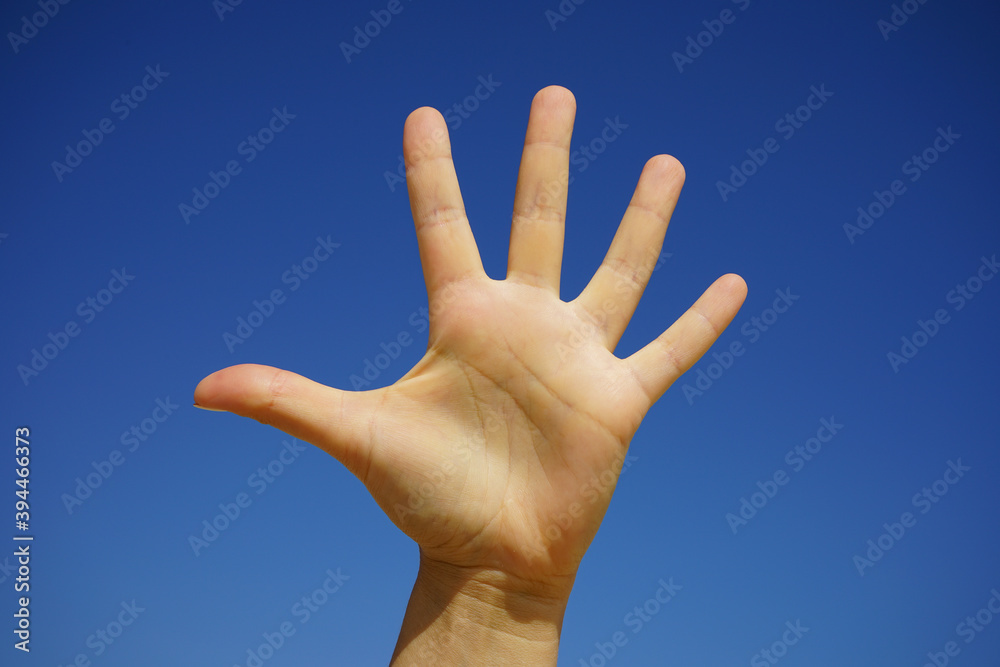 female hand close-up against a cloudless blue sky female hand close-up against a cloudless blue sky