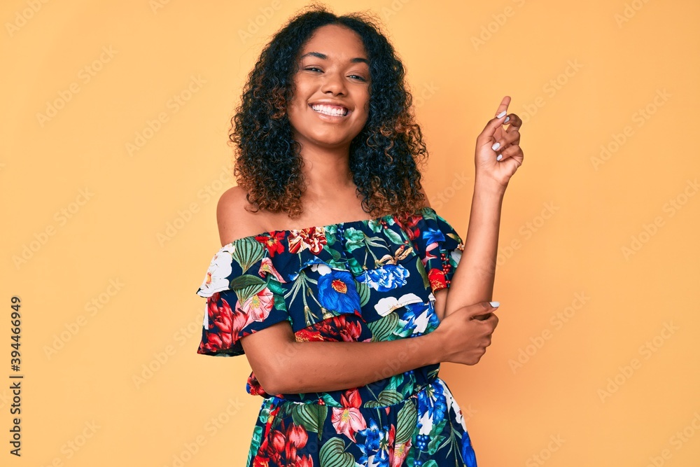 Young african american woman wearing casual clothes with a big smile on face, pointing with hand and finger to the side looking at the camera. Young african american woman wearing casual clothes with a big smile on face, pointing with hand and finger to the side looking at the camera.