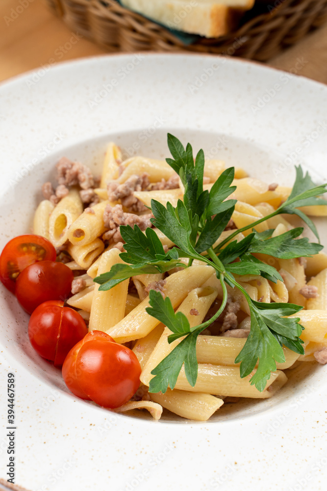 Italian penne pasta with cherry tomatoes and minced meat, close up Italian penne pasta with cherry tomatoes and minced meat, close up