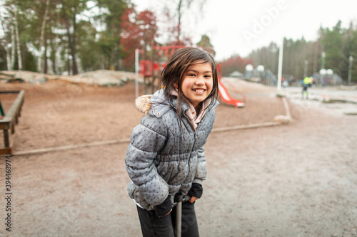 Happy girl on pogo stick looking at camera, Sweden photo