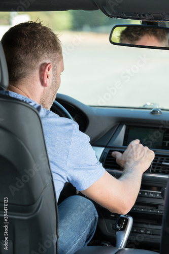 man finger pressing the emergency lights button while driving