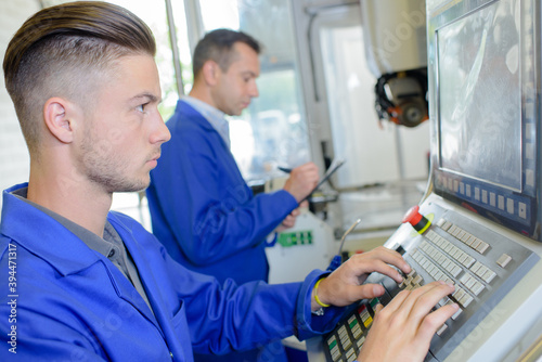 Young operative using computer in factory