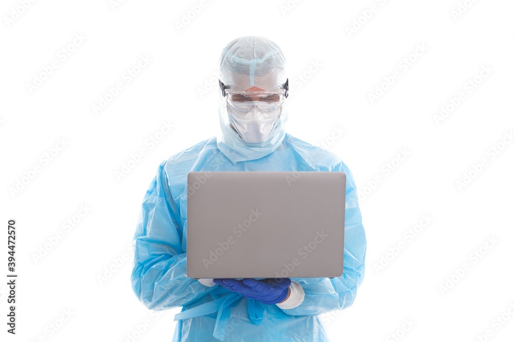 man doctor epidemiologist wearing respirator mask and safety protective costume during coronavirus pandemic outbreak distace working on computer, online help. man doctor epidemiologist wearing respirator mask and safety protective costume during coronavirus pandemic outbreak distace working on computer, online help.