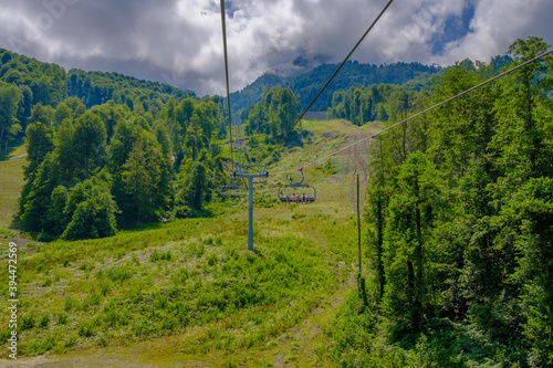 Ski lift in the mountains near the city of Sochi in summer. Scenic view with beautiful clouds over the Caucasus Mountains. Sunny day.