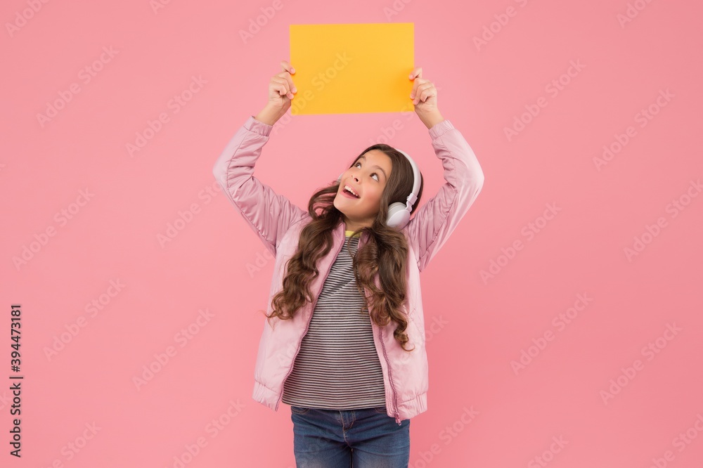 just look at that. back to school. child hold empty paper for copy space. online education announcement. advertising technology. childhood development. happy kid in headphones listen music just look at that. back to school. child hold empty paper for copy space. online education announcement. advertising technology. childhood development. happy kid in headphones listen music