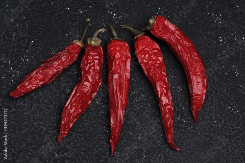 red hot dried chili peppers on a black concrete textured table