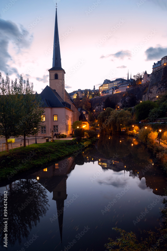 Church of Saint John in Grund, Neimenster, Luxembourg historical centre at sunset with reflection in the water