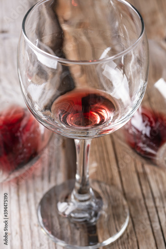 Close-up view of glass with the remains of red wine on on a rustic wooden background. Copy of the space. Alcoholic drinks concept.