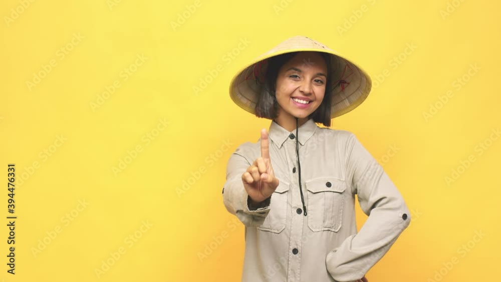 Young latin woman with vietnamite hat showing number one with finger Young latin woman with vietnamite hat showing number one with finger