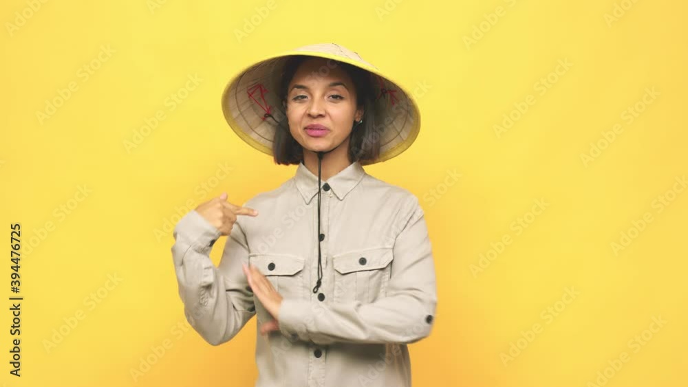Young latin woman with vietnamite hat person pointing by hand to a shirt copy space, proud and confident Young latin woman with vietnamite hat person pointing by hand to a shirt copy space, proud and confident