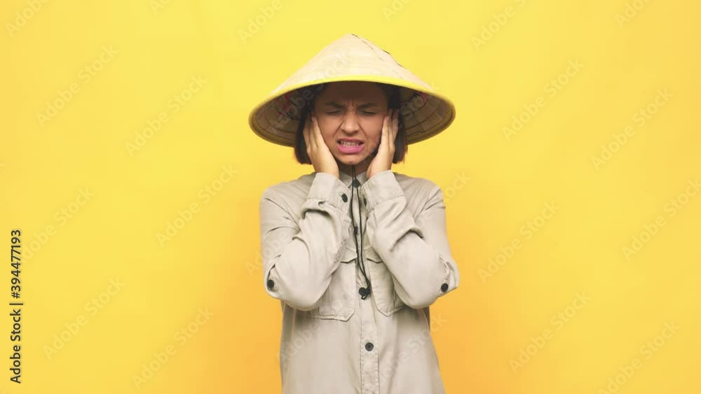 Young latin woman with vietnamite hat covering ears with hands Young latin woman with vietnamite hat covering ears with hands