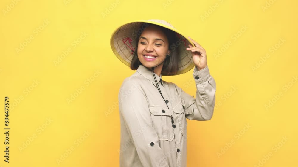 Young latin woman with vietnamite hat looks aside smiling, cheerful and pleasant Young latin woman with vietnamite hat looks aside smiling, cheerful and pleasant