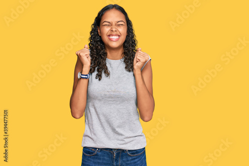 Young african american girl wearing casual clothes excited for success with arms raised and eyes closed celebrating victory smiling. winner concept.