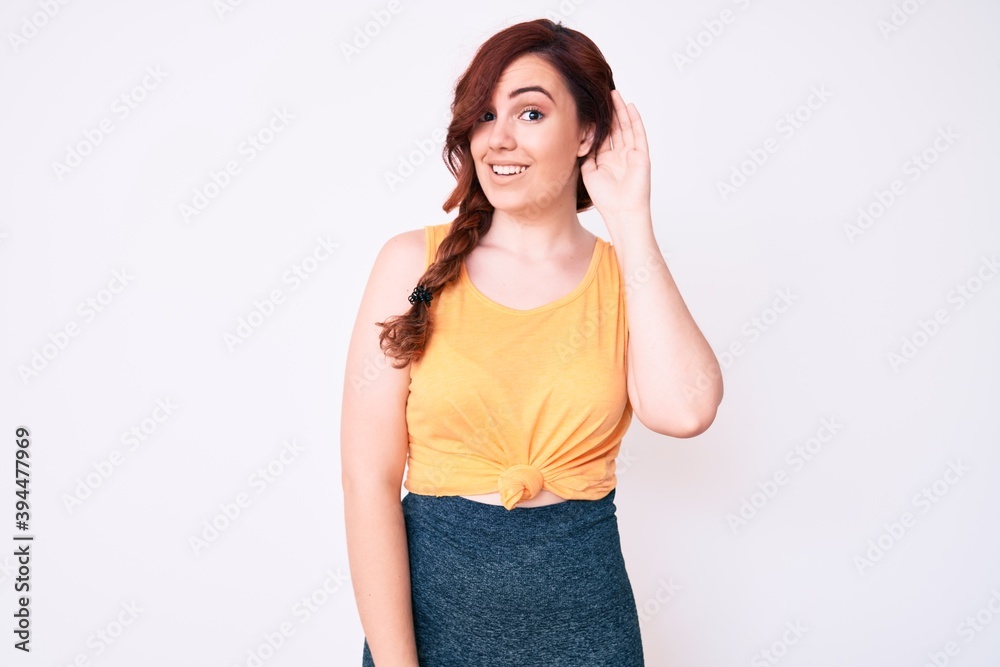 Young beautiful woman wearing casual clothes smiling with hand over ear listening and hearing to rumor or gossip. deafness concept. Young beautiful woman wearing casual clothes smiling with hand over ear listening and hearing to rumor or gossip. deafness concept.